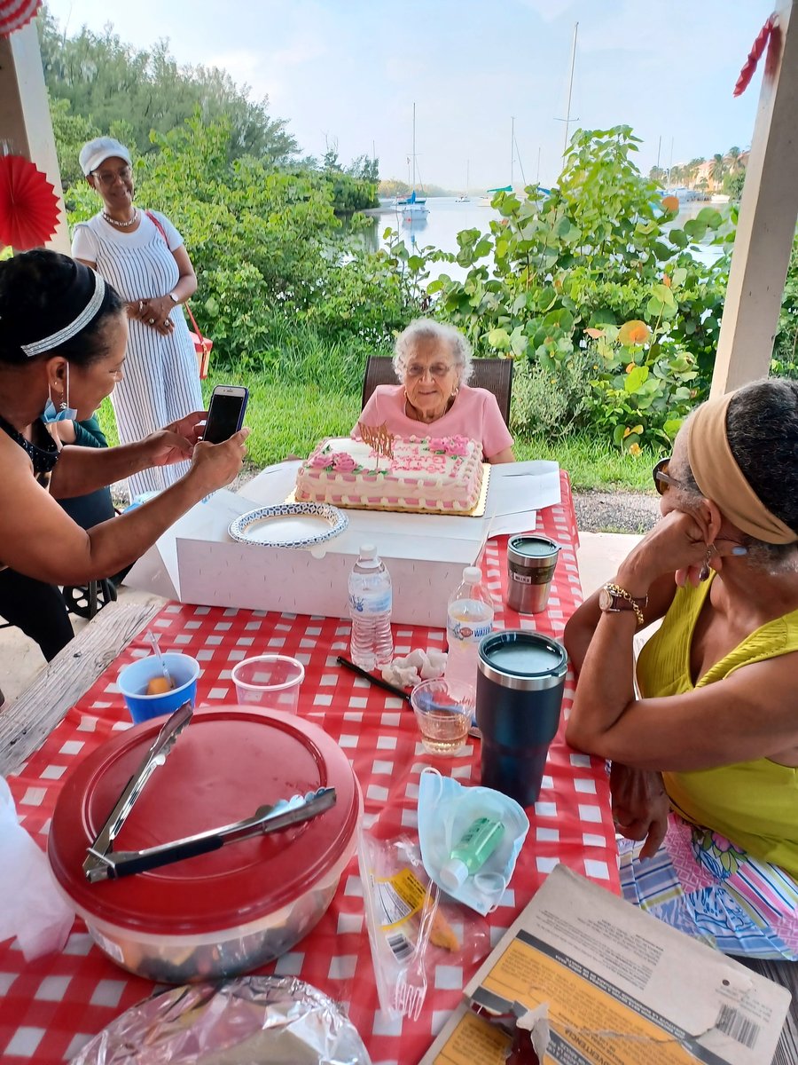 Aileen at her birthday celebration by the water, with family around the table
