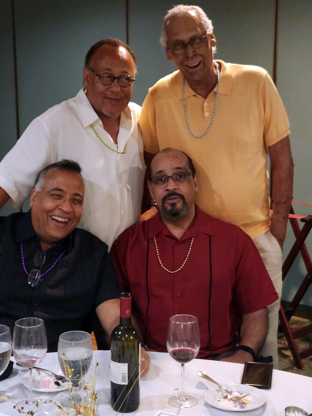 Tony with his brothers, smiling around a dinner table